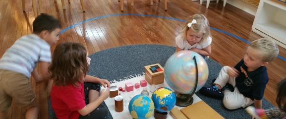 Children are learning about the world with a globe