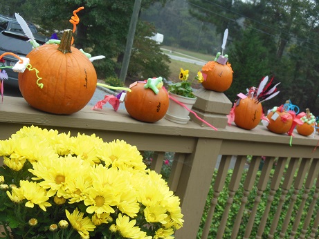 decorated pumpkins on fence
