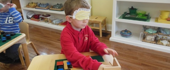 Blindfolded child tries to identify the shapes of objects