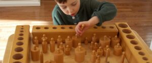 The boy is busy working with small cylinders