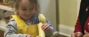 The girl peels a banana during the Open House Event